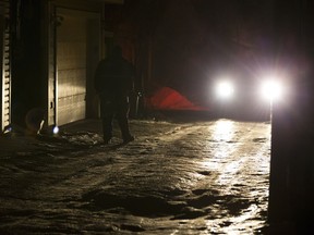 A police officer protects a crime scene in a back alley near 83 Avenue and 97 Street on Wednesday, Dec. 6, 2017 in Edmonton.