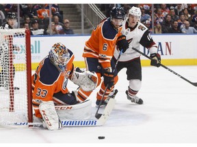 Phoenix Coyotes' Christian Dvorak (18) and Edmonton Oilers' Adam Larsson (6) battle in front as goalie Cam Talbot (33) makes the save during third period NHL action in Edmonton on Tuesday November 28, 2017.