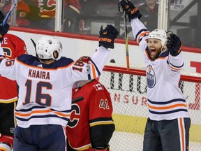 Calgary Flames goalie Mike Smith looks up as Edmonton Oilers' Jujhar Khaira, left, celebrates his goal with Zack Kassian during first period NHL hockey action in Calgary, Saturday, Dec. 2, 2017.