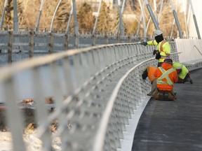 Workers undertake some final clean up on the new Walterdale Bridge's Shared Use Path before it opens to the public on Dec. 21 in Edmonton, Alberta.