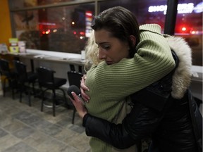 Grace Williams, a tenant on the fourth floor, gets a hug from Postmedia reporter Claire Theobald while recounting seeing a man burn in a fire that struck the Oliver Place apartment complex at 117 Street and Jasper Avenue in Edmonton, Alberta on Thursday, January 19, 2017. Five hundred people were evacuated in the two alarm fire.