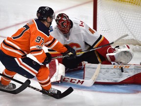 Edmonton Oilers Connor McDavid (97) goes in on Calgary Flames goalie Mike Smith who makes the save during the season opener of NHL action at Rogers Place in Edmonton, October 4, 2017.