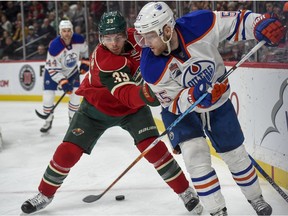 Edmonton Oilers' center Mark Letestu, right, passes the puck back and through the legs of Minnesota Wild defenseman Nate Prosser (39) during the second period of an NHL hockey game, Friday, Dec. 9, 2016, in St. Paul, Minn.