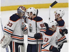 Edmonton Oilers goalie Cam Talbot (33) and teammate Brandon Davidson (88) celebrate after a 3-2 win over the Minnesota Wild on Saturday, Dec. 16, 2017, in St. Paul, MN.