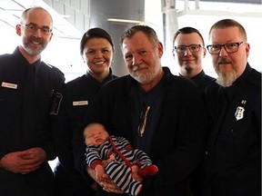 Edmonton Canadian Border Services Agencies (CBSA) officers pose with a man after helping revive him when he had a heart attack in the arrivals area of the Edmonton International Airport on March 24, 2017.