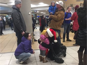 Brenda Plowman, right, hugs her granddaughter Jordyn Plowman, 3, at the Edmonton International Airport on Christmas Day, Dec. 25, 2017, while mom Christina Plowman looks on.