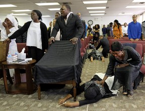 Congregation members collapse as they are overcome with grief and anguish during a church service at Solid Rock Church International in Edmonton on Sunday September 24, 2017. Three women from the church congregation died and a fourth was transported to hospital in Edmonton after a stolen heavy-duty, flat-deck truck collided with a minivan on Highway 16 east of Edmonton. The wife of the church pastor was one of the victims killed in the crash. The chair draped in a black cloth is the seat that the pastor's wife used to sit in during church services. An ambulance was called to the church to treat the members who collapsed in grief.