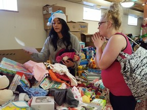 Jaimie Gessner, mother of seven, selects gifts with the assistance of volunteer Kim Guanlao at Bissell Centre West, 10530 – 96 St., in Edmonton, Alta. on Dec. 18, 2017. Donated items are gifted to families enrolled in Bissell Centre programs as part of the centre's Festive Giveaway event.