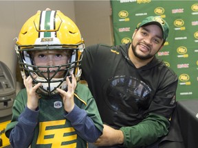 Jack Gaucher, age 6, has his newly purchased helmet signed by Eskimos fullback Calvin McCarty at Commonwealth Stadium as part of the annual locker room sale.