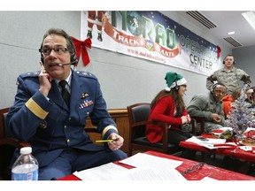 In this Dec. 24, 2014, file photo, Canadian Brig. Gen. Guy Hamel, NORAD and USNORTHCOM Deputy Director of Policy, Strategy, and Plans, joins other volunteers taking phone calls from children around the world asking where Santa is and when he will deliver presents to their homes, inside a phone-in centre at the North American Aerospace Defense Command, at Peterson Air Force Base, Colo.