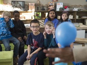 Science teacher Maz Nelson holds onto a balloon stretched over the top of a bottle as part of a carbon dioxide experiment in the Grade 2 class at St. Richard School on Nov. 30, 2017.