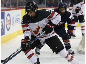 Canada defence Meaghan Mikkelson skates the puck away from a United States attacker in a pre-Olympic series exhibition game in Winnipeg on Tues., Dec. 5, 2017.