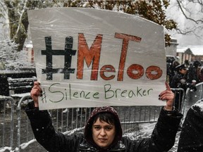 People carry signs addressing the issue of sexual harassment at a #MeToo rally outside of Trump International Hotel on December 9, 2017 in New York City.