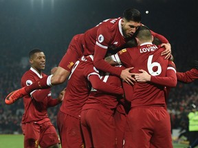 Liverpool's Emre Can jumps into the celebration after a goal against Manchester City on Sunday. (GETTY IMAGES)