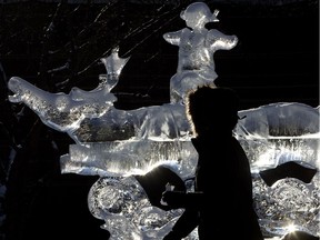A woman walks past an ice sculpture during the Ice on Whyte festival in Edmonton one Sunday Feb. 5, 2017.