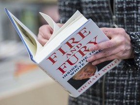 A man holds a copy of the book Fire and Fury: Inside the Trump White House by Michael Wolff after buying it at a bookstore in Washington, D.C., on Jan. 5, 2018.