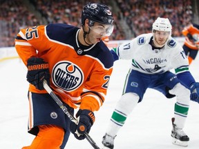 Darnell Nurse #25 of the Edmonton Oilers is pursued by Nic Dowd #17 of the Vancouver Canucks at Rogers Place on January 20, 2018 in Edmonton.