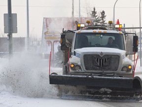 A City of Edmonton snow plow clears snow off of 82 Avenue in Edmonton, Alta., on Saturday, Dec. 21, 2013.
