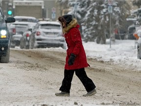 A pedestrian crosses the street in downtown Edmonton on Friday Jan. 26, 2018. Heavy snowfall and falling temperatures have returned to the Edmonton region.