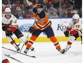 Edmonton Oilers captain Connor McDavid (97) shoots past Calgary Flames forward Johnny Gaudreau (13) at Rogers Place in Edmonton on Thursday, Jan. 25, 2018. (Ian Kucerak)