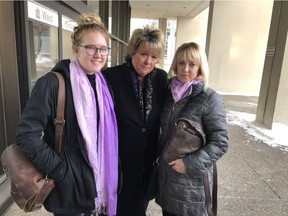 Aileen (Gina) Robinson's sister, Michelle Chimko, centre, is supported by friends Blaire Oosterhuis and Treena Oosterhuis outside the Edmonton courthouse on Jan. 27, 2018.
