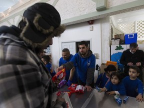 Mohamed Rahall with Islamic Relief hands out hand wipes on Saturday, Jan. 27, 2018 at the Mustard Seed in Edmonton. The event is to distribute winter items and other essentials to residents of the inner-city.