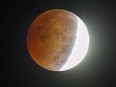 During a lunar eclipse, the moon appears orange or red, the result of sunlight scattering off Earth's atmosphere.