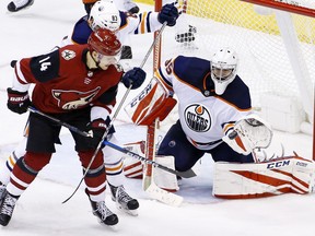 Edmonton Oilers goaltender Al Montoya (35) makes a glove save as Arizona Coyotes right wing Richard Panik (14) and Oilers defenseman Matt Benning (83) works for position during the third period of an NHL hockey game Friday, Jan. 12, 2018, in Glendale, Ariz. The Oilers defeated the Coyotes 4-2.