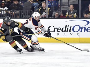 Edmonton Oilers center Connor McDavid (97) skates with the puck under pressure from Vegas Golden Knights center William Karlsson during the first period of an NHL hockey game Saturday, Jan. 13, 2018, in Las Vegas.