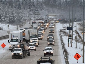Traffic goes around a tractor-trailer unit that was pulled off onto the shoulder on Whitemud Drive as a snow storm hit Edmonton on Friday, Jan. 26, 2018.