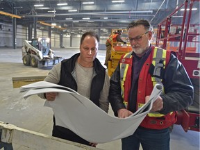 Troy Dezwart, co-founder of Freedom Cannabis Inc., left, and Aubrey Komant, construction superintendent, looking over drawings  at a 125,000-square-foot cannabis production facility under construction at the Acheson Industrial area west of Edmonton on Feb. 23, 2018.