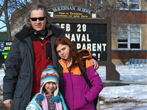 Semyon Chaichenets with his daughters, Anna, 10, who is in the Extensions program for gifted kids and Maria, 6, pose in front of McKernan School in Edmonton, February 27, 2018.