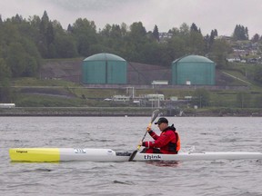 A kayaker paddles past the Kinder Morgan yard in Burrard Inlet in North Vancouver, B.C. File photo.