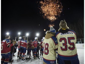 Brent Saik, right, and his daughter Angelica Saik watch as fireworks close the World's Longest Hockey Game near Sherwood Park, Alberta Monday Feb. 19, 2018.