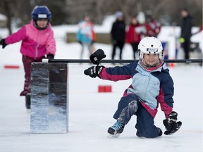 Quinn Salisbury, 5, left, and Siobhan Gillis, 6, make their way through an obstacle course while taking part in a Red Bull Crashed Ice family event in Edmonton's Rundle Park on Saturday, Feb. 24, 2018.