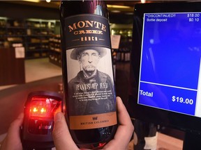 This photo illustration shows a cashier at Jasper Wine Mrkt scanning a B.C. wine bottle with the word discontinued on the screen. The Alberta government announced the boycott of B.C. wines and will stop importing them in the wake of the Trans Mountain pipeline issues. Edmonton, February 6, 2018.