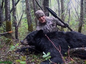 American Josh Bowmar, seen here in a still image made from video, poses with the spear and black bear he killed, which resulted in a public backlash.