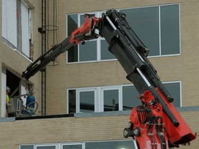 A knuckle boom crane is being used at the former Charles Camsell Hospital site in Edmonton on February 13, 2018. The radio remote crane, valued at approximately $1 million, allows more manoeuverability than a standard crane because it articulates at the "knuckle" near the middle, letting it fold back like a finger.