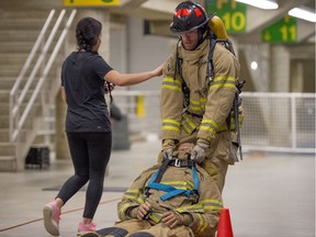 Celine Wong, guides Dan Rombough,  through the cones while dragging an 85kg mannequin. Firefighter applicants endure the physical test conducted with the University of Alberta's Faculty of Kinesiology, Sport and Recreation. The tests are designed to simulate the physical requirements of firefighting.  Ladder climbs, vehicle extractions and victim rescues were part of the demonstration at the Van Vliet Centre. on February 28.