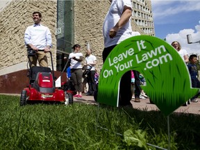 Then-councillor Don Iveson and a group of volunteers prepare to clip a patch of grass in front of City Hall without bags on the mowers in Edmonton, Alta.  The event was meant to promote the practice of leaving grass clippings on the grass when mowing to reduce waste and conserve water. File photo.