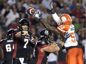 Ottawa Redblacks quarterback Trevor Harris, left, throws the ball past B.C. Lions defensive end Alex Bazzie during CFL action on Aug. 25, 2016 in Ottawa.