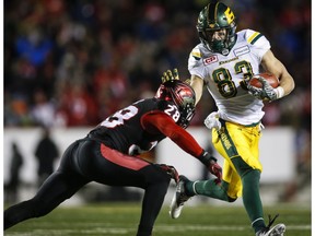 Edmonton Eskimos' Brandon Zylstra, right, runs the ball as Calgary Stampeders' Brandon Smith closes in during second half CFL West Final football action in Calgary, Sunday, Nov. 19, 2017.