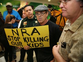 A protester holds a sign that reads, 'NRA Stop Killing Our Kids', outside the court-room where Nikolas Cruz, 19, a former student at Marjory Stoneman Douglas High School in Parkland, Florida, was having a bond hearing in front of Broward Judge Kim Mollica at the Broward County Courthouse on February 15, 2018 in Fort Lauderdale, Florida.