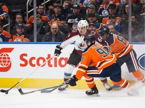 Edmonton Oilers' Jesse Puljujarvi (98) and Brandon Davidson (88) defend against Colorado Avalanche's Nail Yakupov (64) during first period NHL action in Edmonton on Thursday, Feb. 1, 2018.