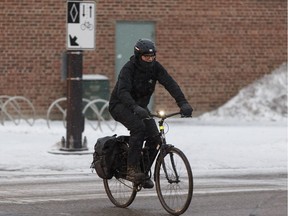 A cyclist rides along 83 Avenue in the bike lane in winter gear during a snowstorm in Edmonton on Jan. 25, 2018. Edmonton, Alberta on Thursday, Jan. 25, 2018.