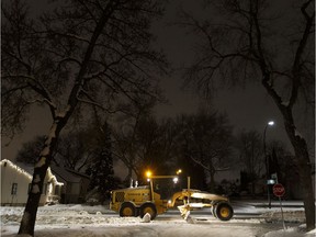 A City of Edmonton grader works on a cold night along 112 Avenue at 67 Street in Edmonton, Alberta on Jan. 30, 2018.