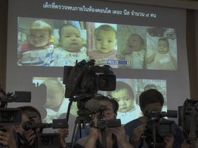 FILE - In this Aug. 12, 2014, file photo, the media attend a press briefing where Thai police display projected pictures of surrogate babies born to a Japanese man who is at the center of a surrogacy scandal during a press conference at the police headquarters in Chonburi, Thailand. The Japanese father of the surrogate babies Mitsutoki Shigeta is the son of the founder of Japanese telecom and insurance company Hikari Tsushin and earns millions of dollars a year in dividends.