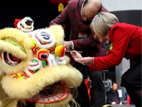 Premier Rachel Notley dots the eye of a lion dancer with help from Henry Fung, vice chair with the Edmonton Chinatown Multi-Cultural Centre, in a traditional ceremony during the Edmonton Chinatown Multicultural Centre Lunar New Year Extravaganza at West Edmonton Mall on Saturday, Feb. 3, 2018.