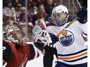 Arizona Coyotes goaltender Antti Raanta reaches in front of Edmonton Oilers left winger Drake Caggiula to catch the puck Saturday, Feb. 17, 2018, in Glendale, Ariz.