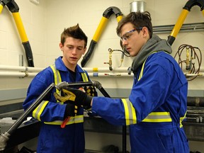 Dylan Johanson (left, 16) and Phillip Salisbury (right, also 16) are in the plumbing program at Archbishop O'Leary High School, the first Catholic school in Edmonton to offer a plumbing lab where students can begin to train for the plumbing trade.